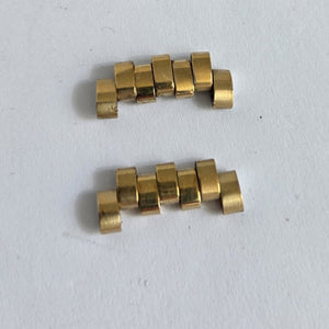 Two gold metal components on a white background