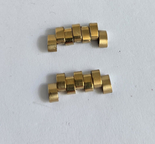 Two gold metal components on a white background